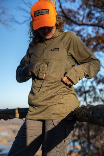 female wearing the Helio Hoody and zipping a side front pocket
