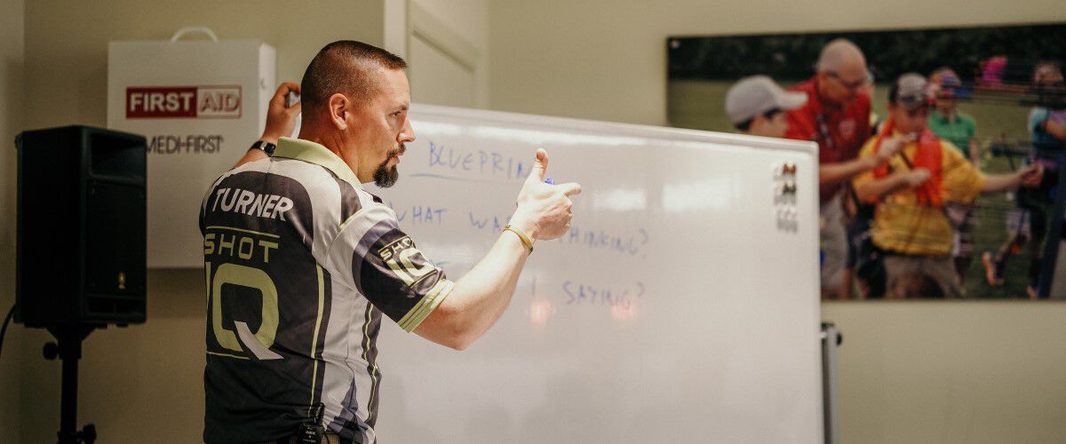 Joel Turner standing in front of a white board with writing