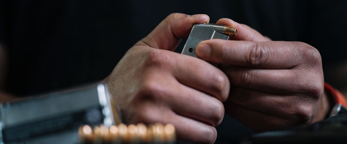 Person loading ammunition into a pistol.