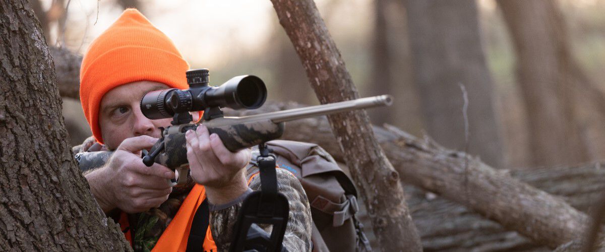 hunter looking down the scope of a rifle