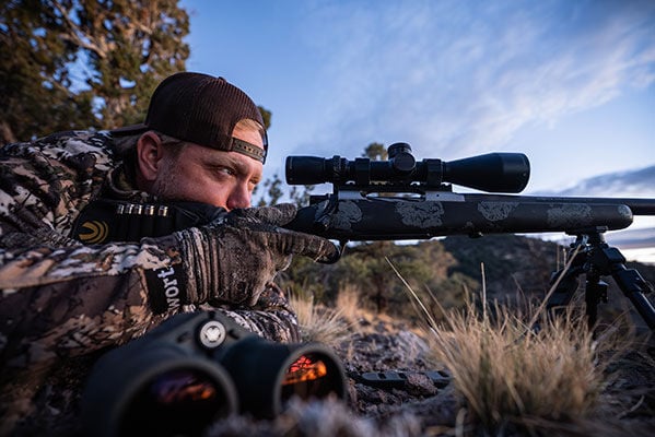Nick looking through a rifle scope