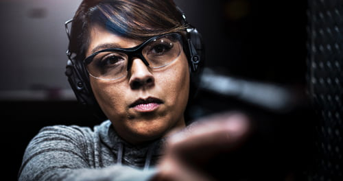 lady aiming pistol at an indoor range