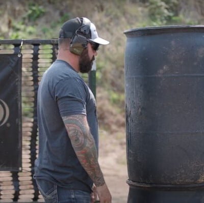 Josh Froelich standing next to a black barrel