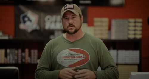 Jim Gilliland standing in front of rows of ammo