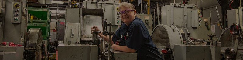 employee standing at factory machine