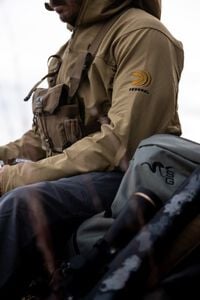 male wearing the De Havilland Jacket and sitting next to a rifle