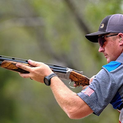 Derrick Mein holding a shotgun
