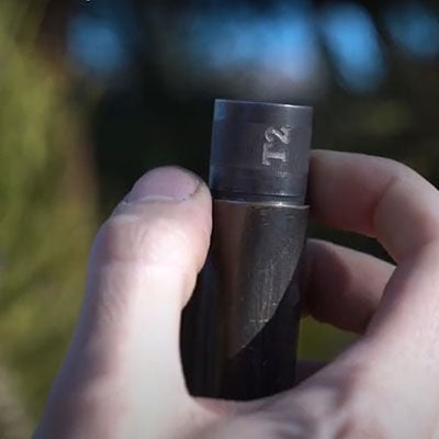 person holding a shotgun choke