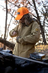 female wearing the De Havilland Jacket and unzipping a front pocket