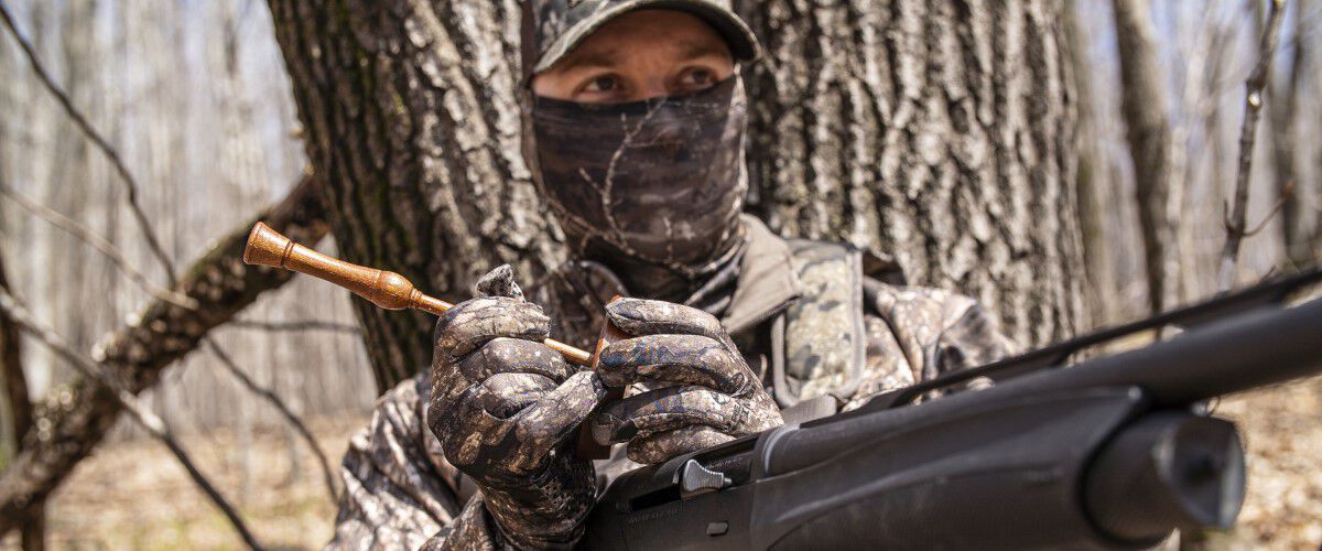 close up of a hunter using a turkey call