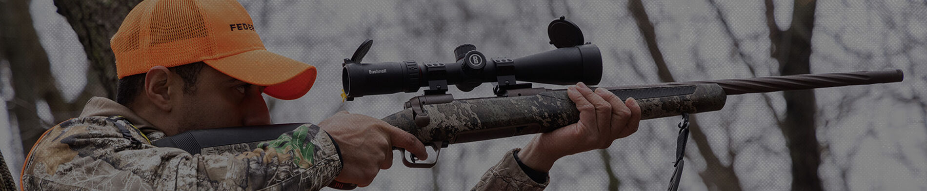 man shooting rifle from a tree stand