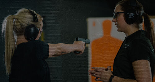 woman shooting a handgun at an indoor range