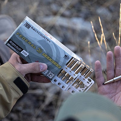 hunter holding 7mm Backcountry box and cartridge
