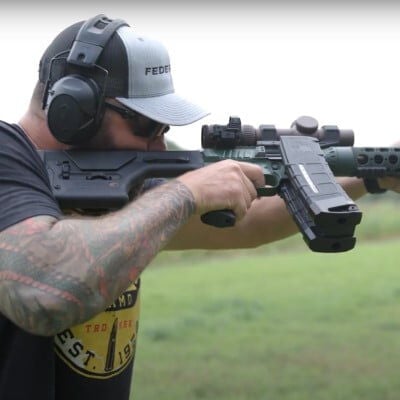 Jim Gilliland looking down the scope of a rifle