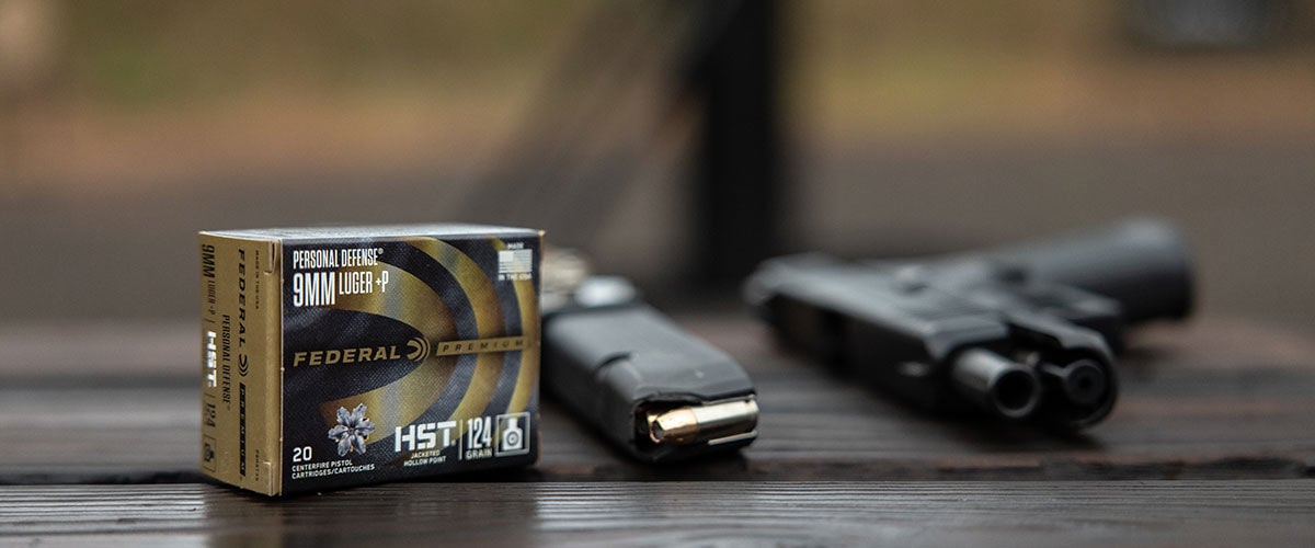 HST pox on a table next to a loaded magazine and handgun