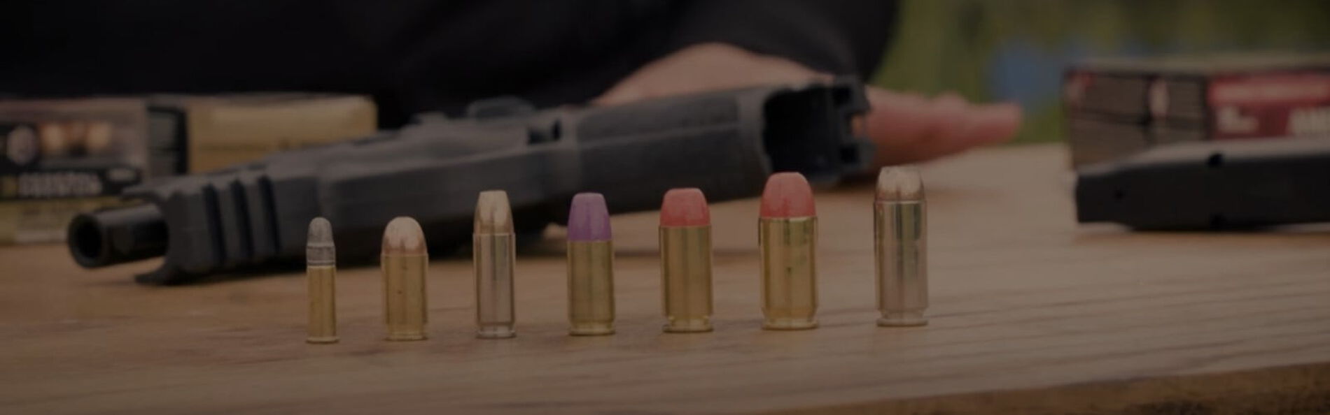 different caliber Federal cartridges lined-up on a table in front of a handgun
