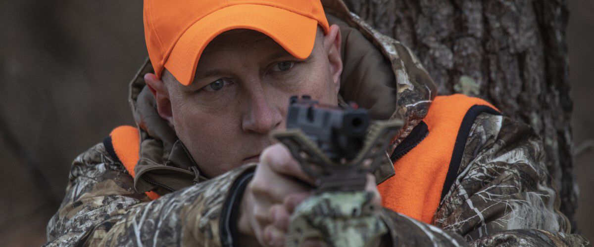 Hunter pointing a handgun