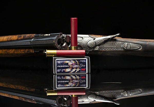 Custom Shotshell box and shotshell in front of a shotgun