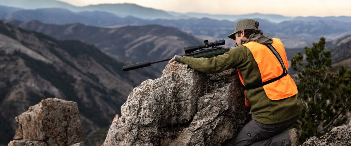 Adult helping child shoot a rifle