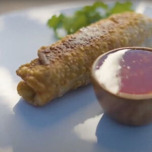 venison egg rolls on a plate with sweet and sour sauce