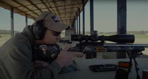 Jim Gilliland looking down the scope of a rifle