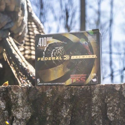 Federal Premium HEAVYWEIGHT TSS .410 Bore box sitting on a tree stump with a dead turkey