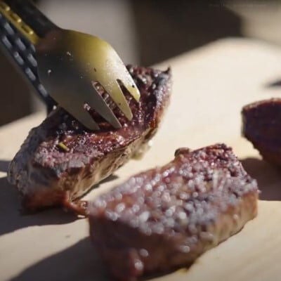 venison steak being put on a cutting board