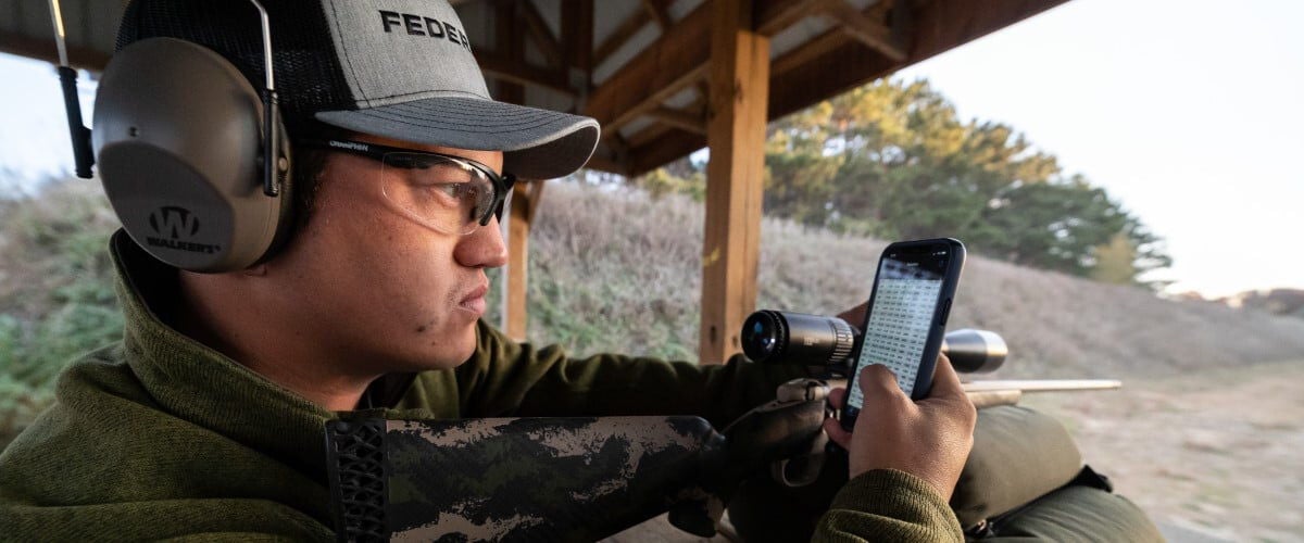 shooter looking at the app at an outdoor range