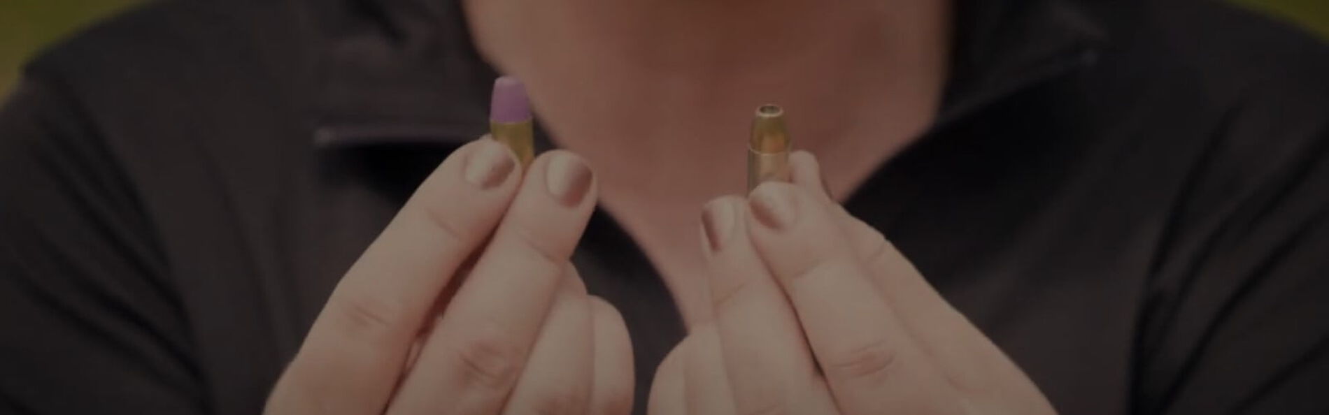 Julie Golob holding two handgun cartridges