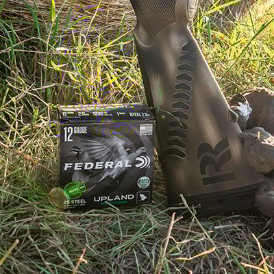 pile of doves and Upland Steel paper wad box and shotgun in the grass