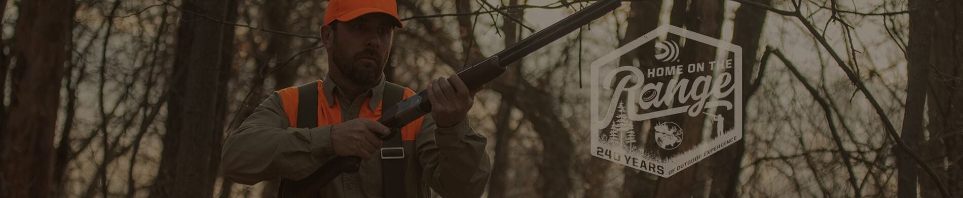 hunter holding shotgun walking through a wooden area