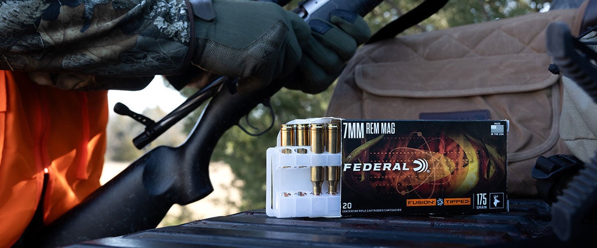 Fusion Tipped box and cartridges on a tailgate next to a hunting loading his gun
