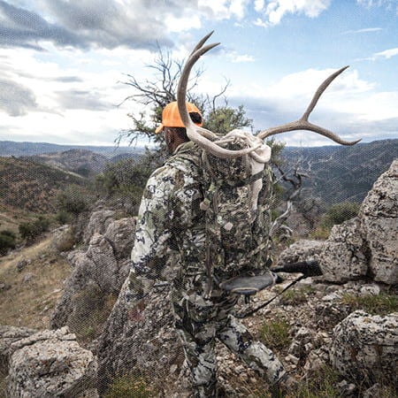 hunter carrying antlers on his back