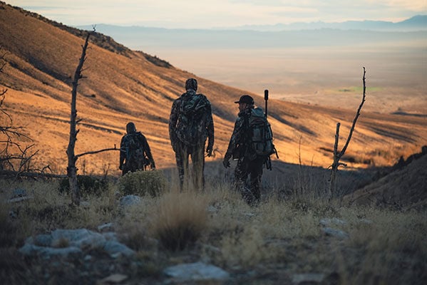 hunters walking through a valley