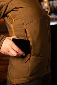 female putting a phone into the pocket of the Cirque jacket