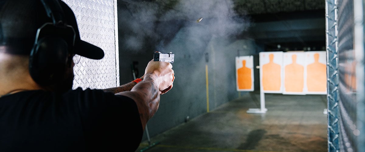 Man shooting pistol at orange target