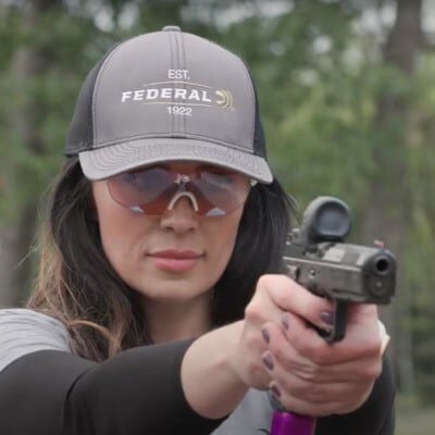 Krystal Dunn looking down the scope of a pistol