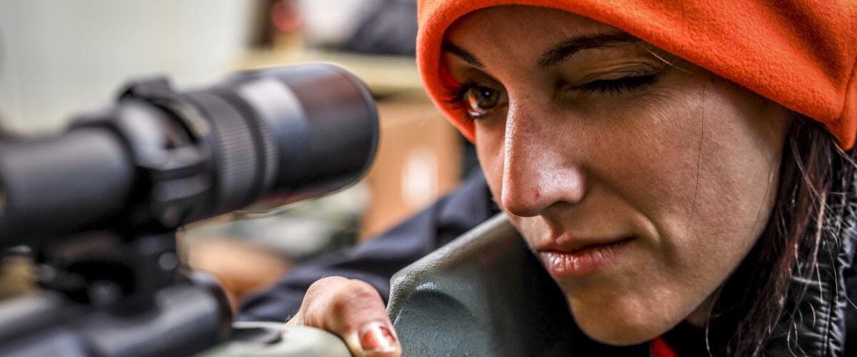 women looking down a rifle scope