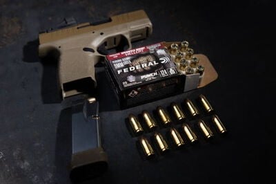 Punch Hellcat packaging and cartridges in front of a Springfield Armory Hellcat
