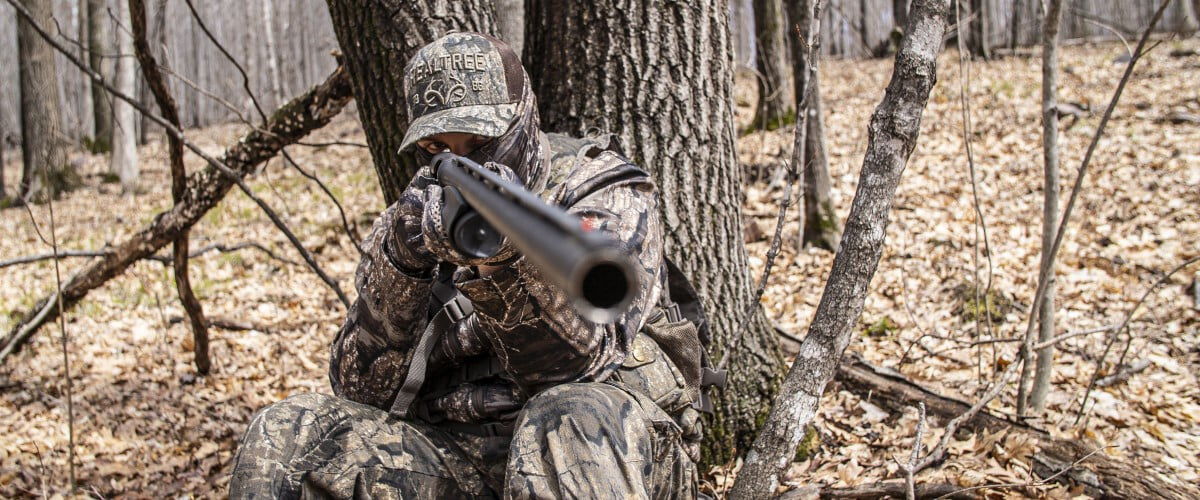 hunter looking down the sites of a shotgun