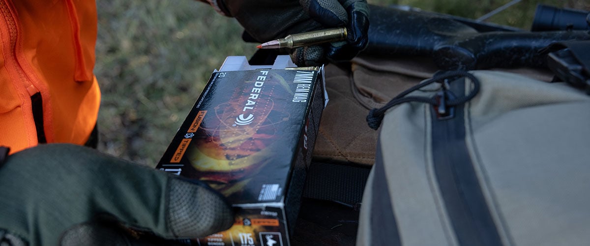 hunter holding 7mm Backcountry box and cartridge