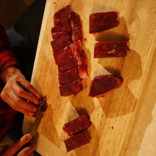 deer tenderloin being trimmed of fat and connective tissue