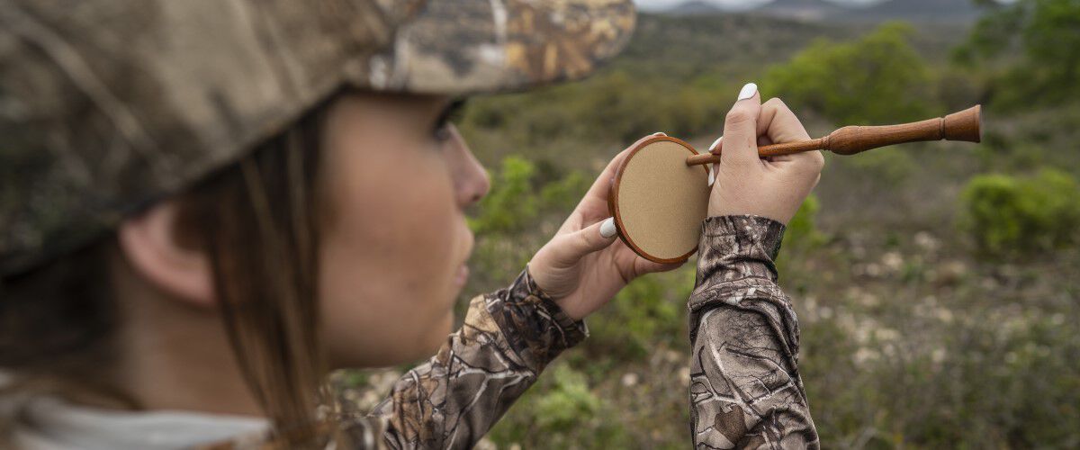 Lady hunter using a turkey call