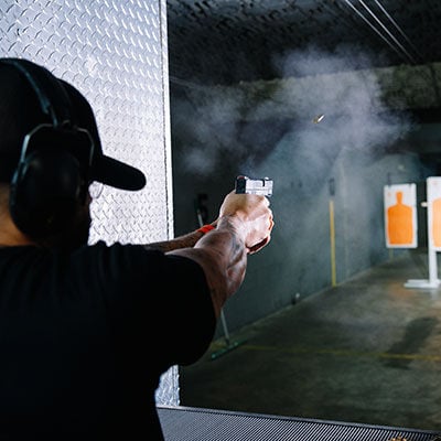 Man shooting pistol at orange target