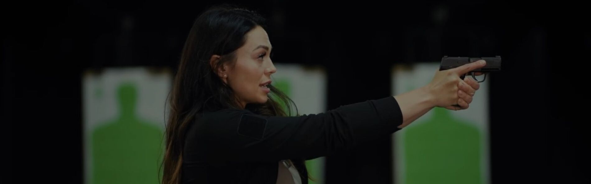 Krystal Dunn aiming pistol at an outdoor range