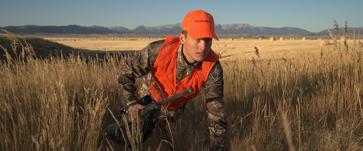 hunter crouching in prairie grass