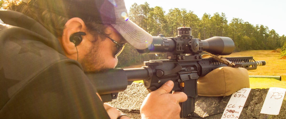 Jim Gilliland looking down the scope of a rifle