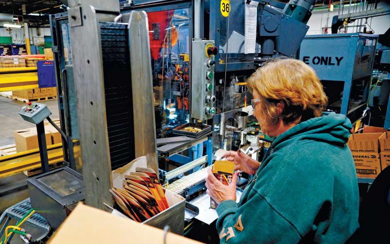 staff working on a press in a factory
