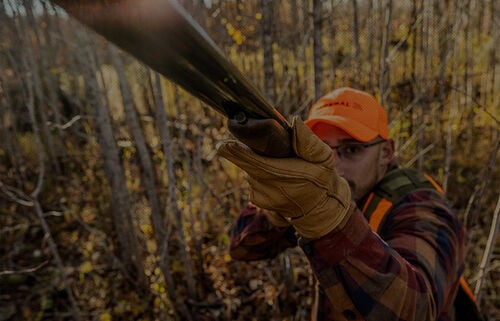 looking down the barrel at a man holding a shotshell