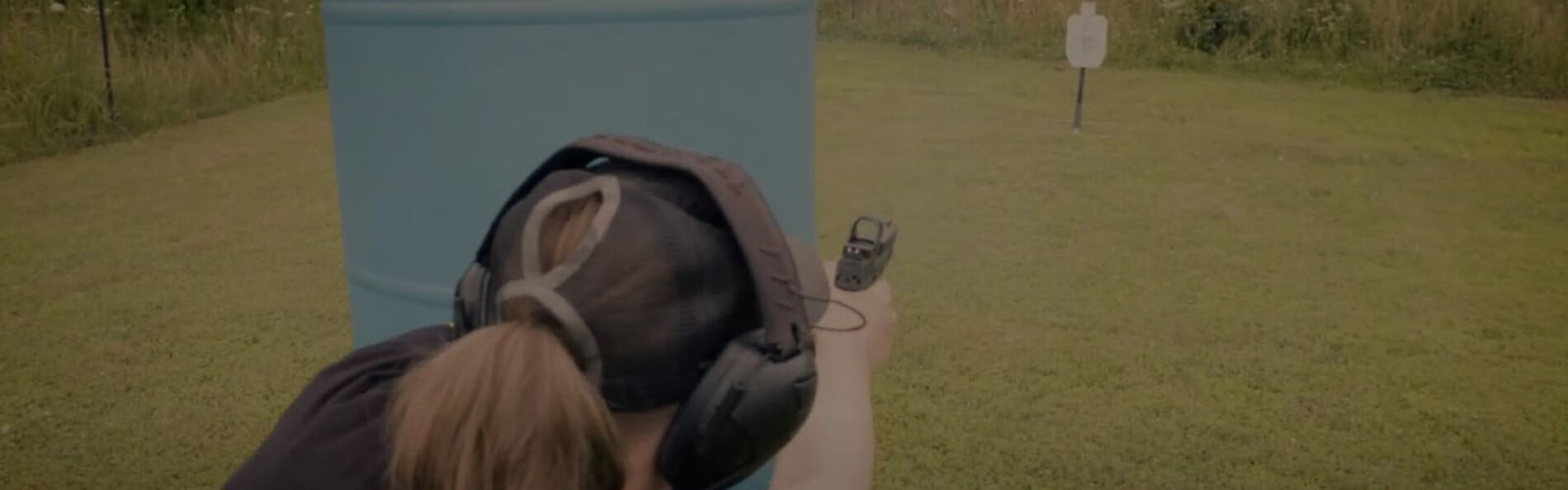 Julie Golob shooting around a barrier outside